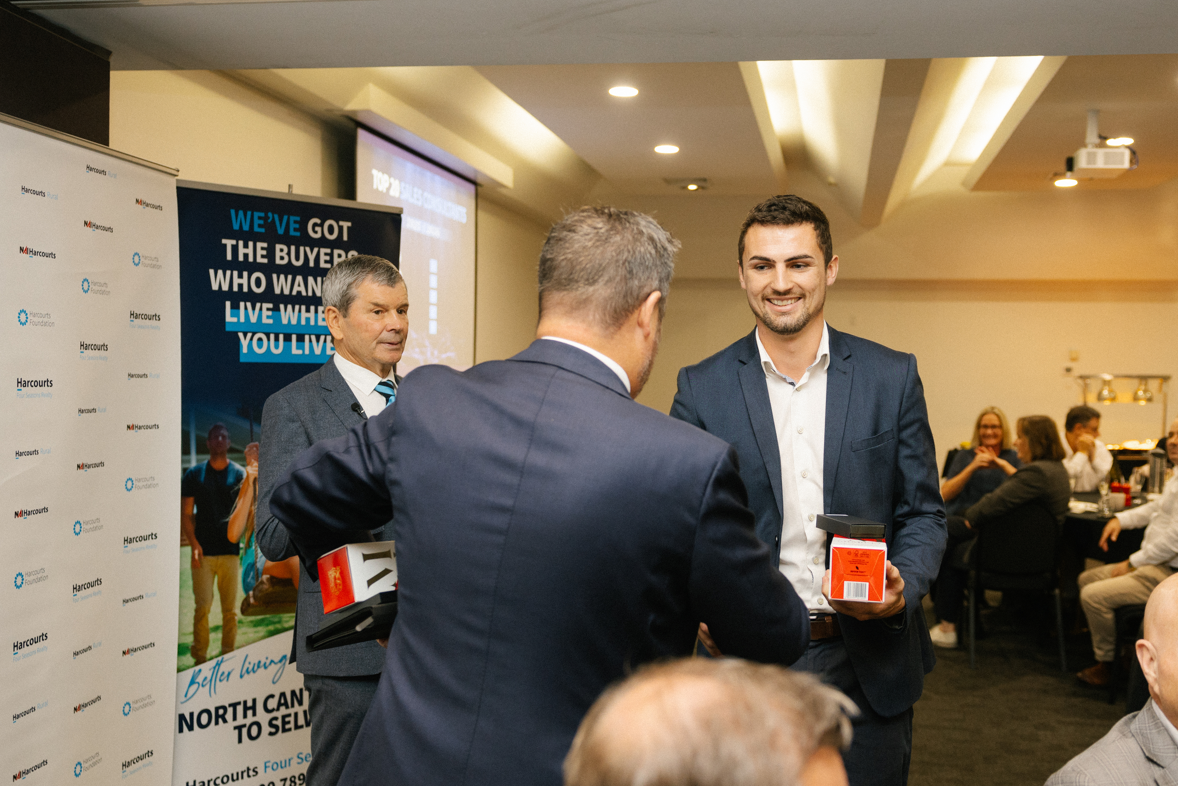 Tait Spain receiving a Harcourts award